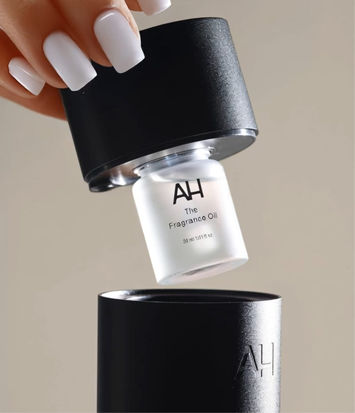 A hand setting the fragrance bottle into the diffuser